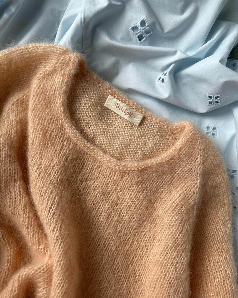 Label på Eva cardigan med Petiteknit logo i biscuit