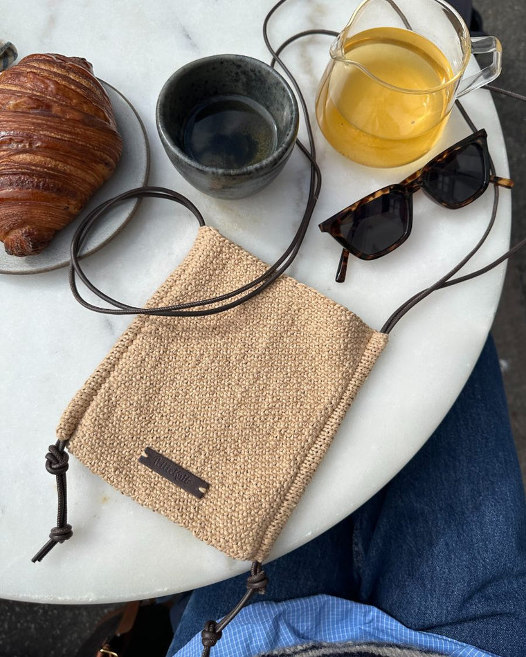 Sienna bag med skindsnører liggende på cafebord